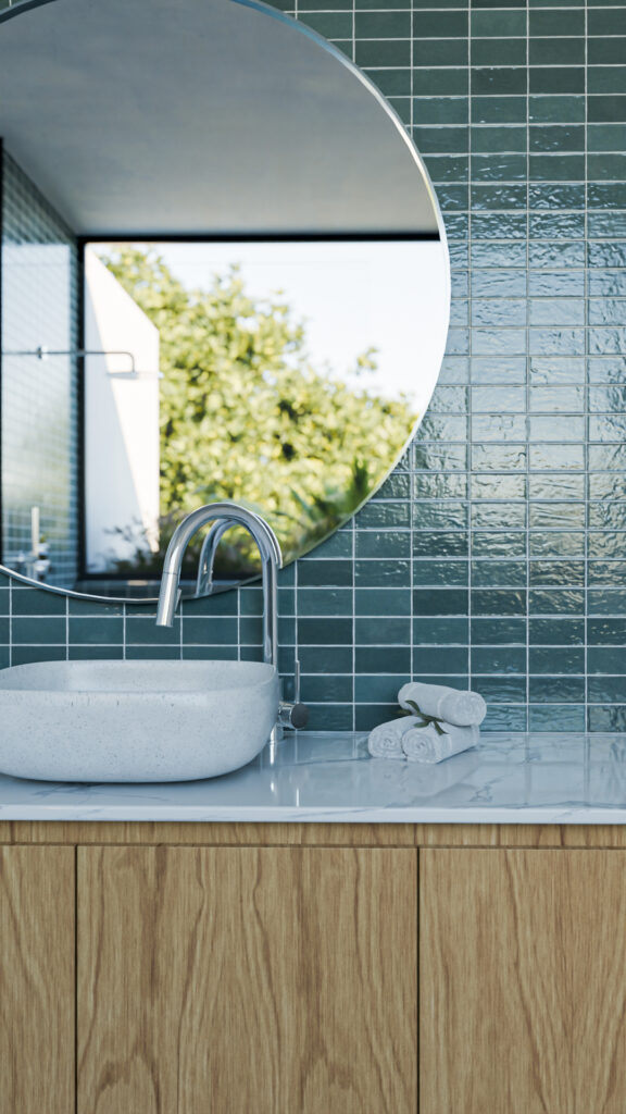 Baño principal destacado por muro de azulejos verdes brillantes, espejo circular, mueble de madera y cancel de cristal