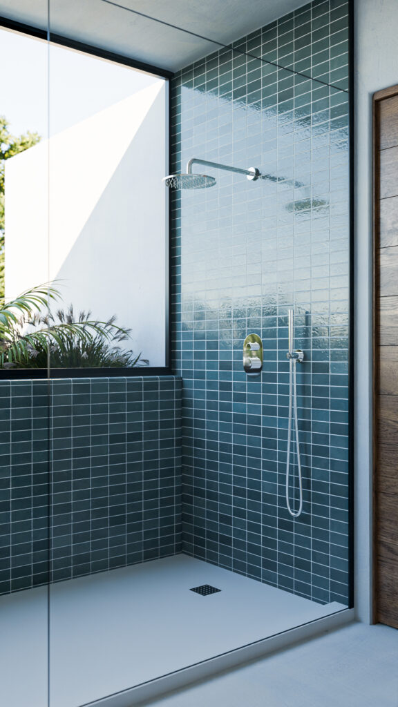 Baño principal destacado por muro de azulejos verdes brillantes, espejo circular, mueble de madera y cancel de cristal