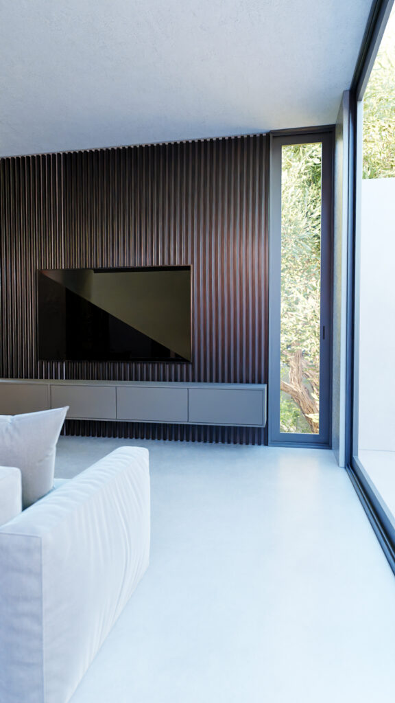 Sala de televisión con muro de madera acanalada oscura, pisos de concreto y ventanales hacia el jardín