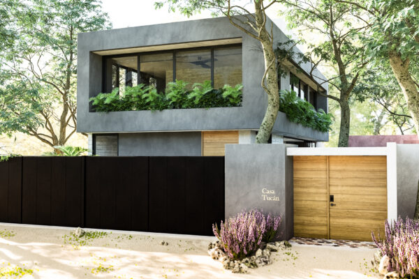 Fachada principal de Casa Tucán con volumen de concreto gris, portón negro y jardinera en planta alta